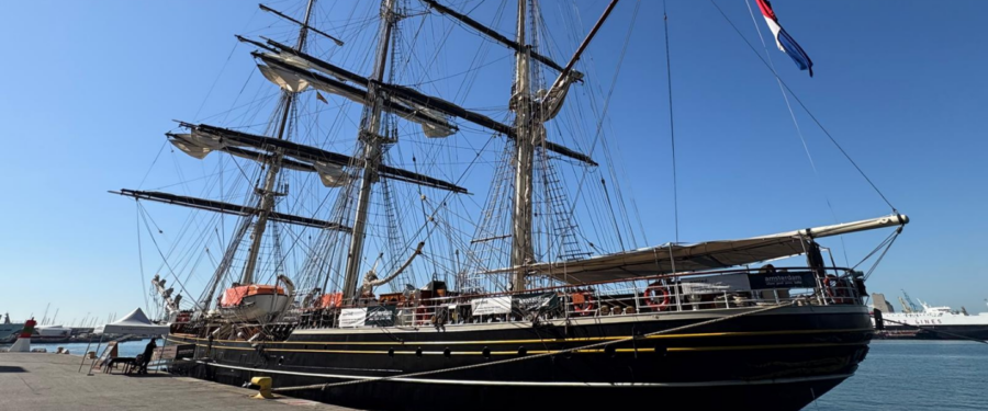 El Clipper Stad Amsterdam atracat al port de Barcelona. El gran veler de tres pals, inspirat en els clippers del segle XIX, destaca per la seva estructura tradicional i les seves 31 veles en un entorn marítim assolellat.