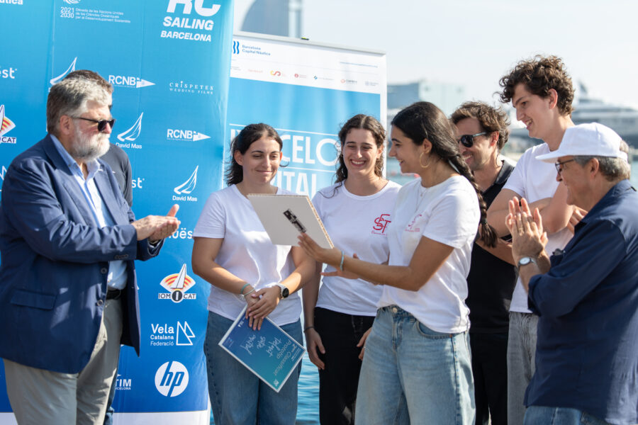 Tres participants de la RC Barcelona Cup 2026 observant les proves de vela radiocontrolada al Port Vell.