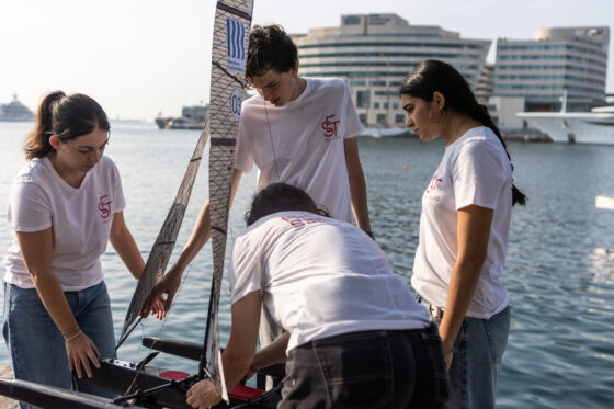 Equip participant en la RC Barcelona Cup 2026, amb una embarcació de vela Raig FNB al darrere.